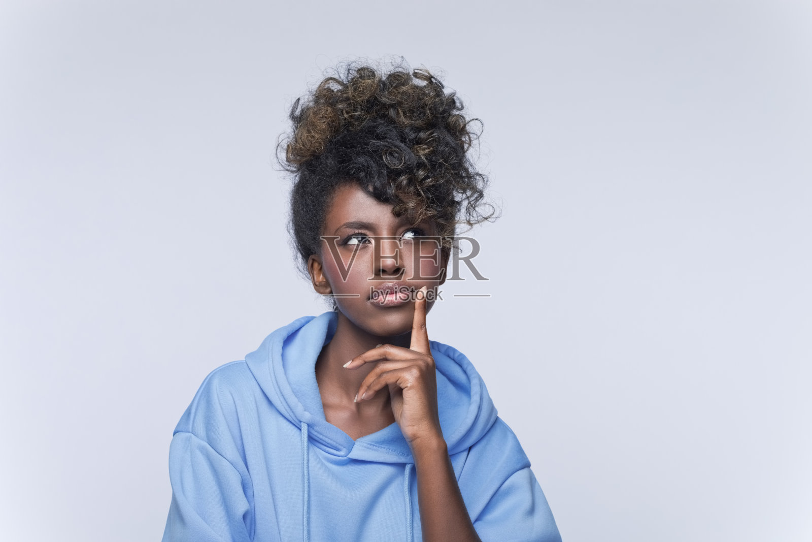 穿着蓝色连帽衫的体贴的年轻女子照片摄影图片