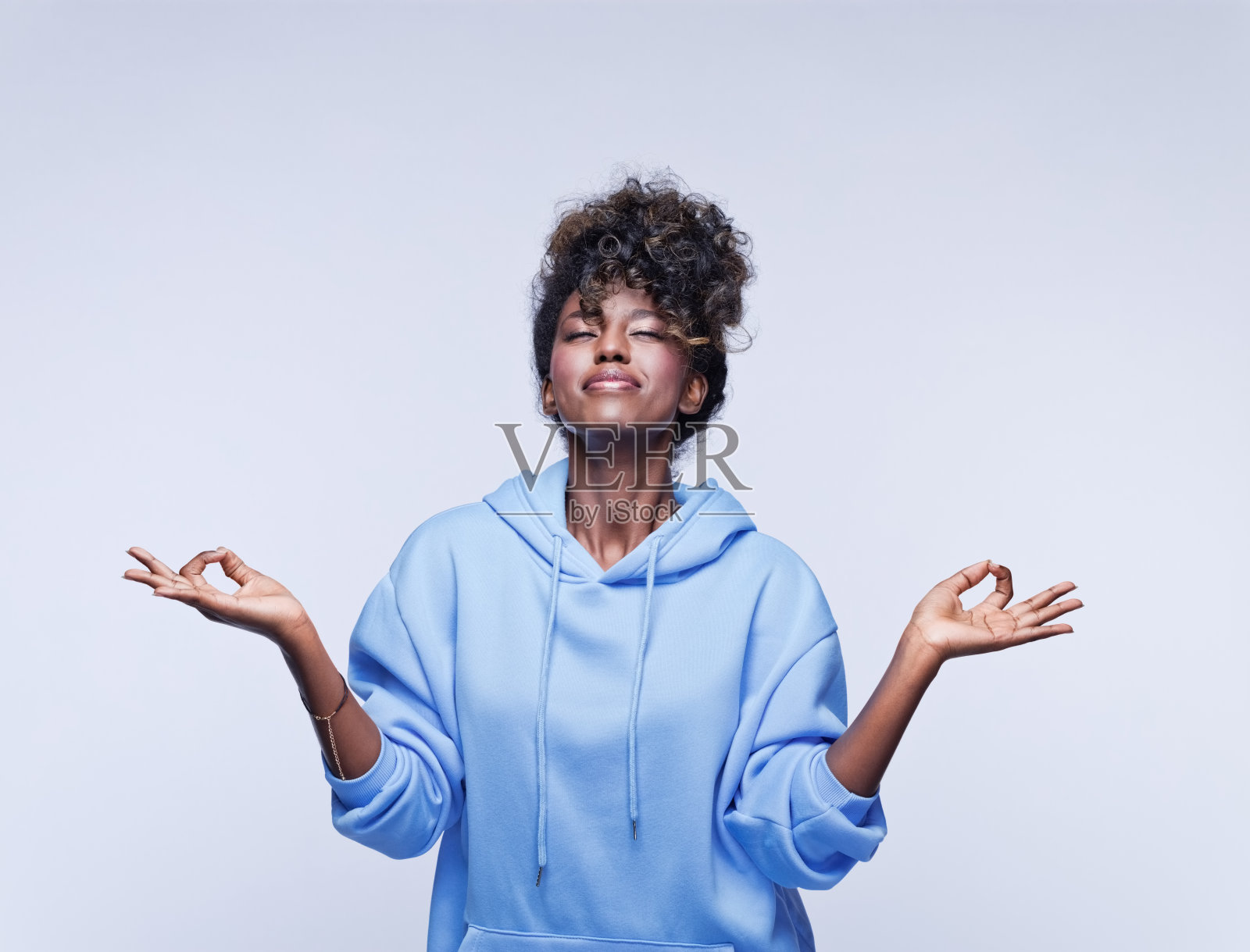 穿着蓝色连帽衫的快乐年轻女子照片摄影图片