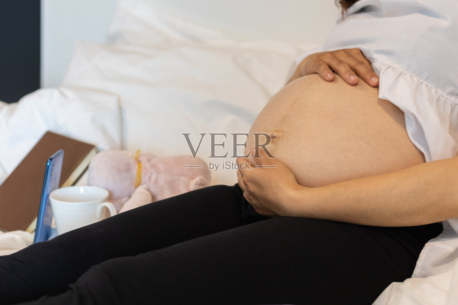 这位准妈妈满怀爱意地把手放在肚子上，因为她感觉到子宫里婴儿的力量，她用自己的信心和力量向上帝祈祷，希望能把孩子生下来，她就安全了照片摄影图片