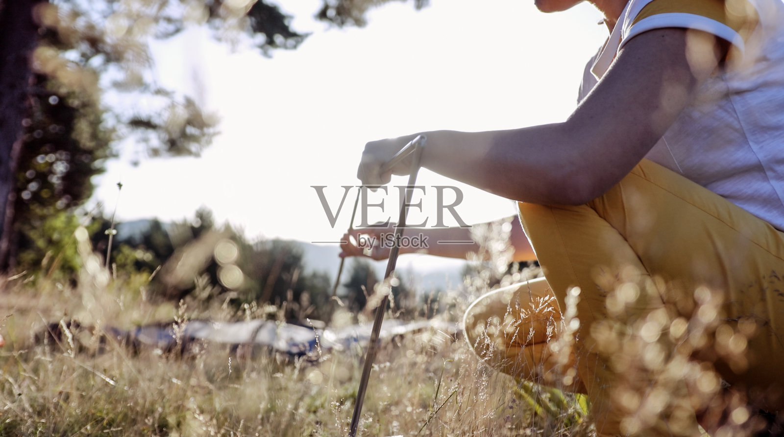 在野外露营时，在日落时搭帐篷。照片摄影图片
