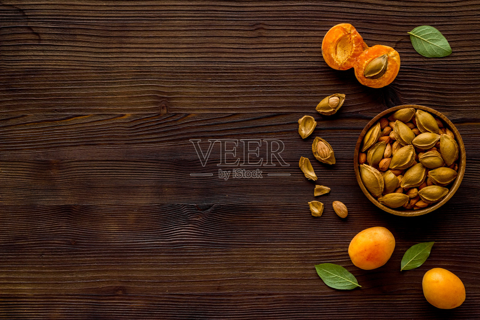 杏和杏核在碗里。俯视照片摄影图片