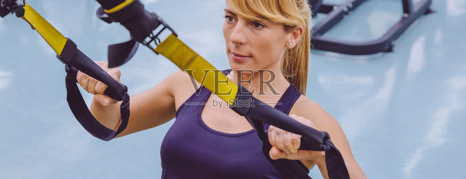 用健身吊带做悬吊训练的女人照片摄影图片