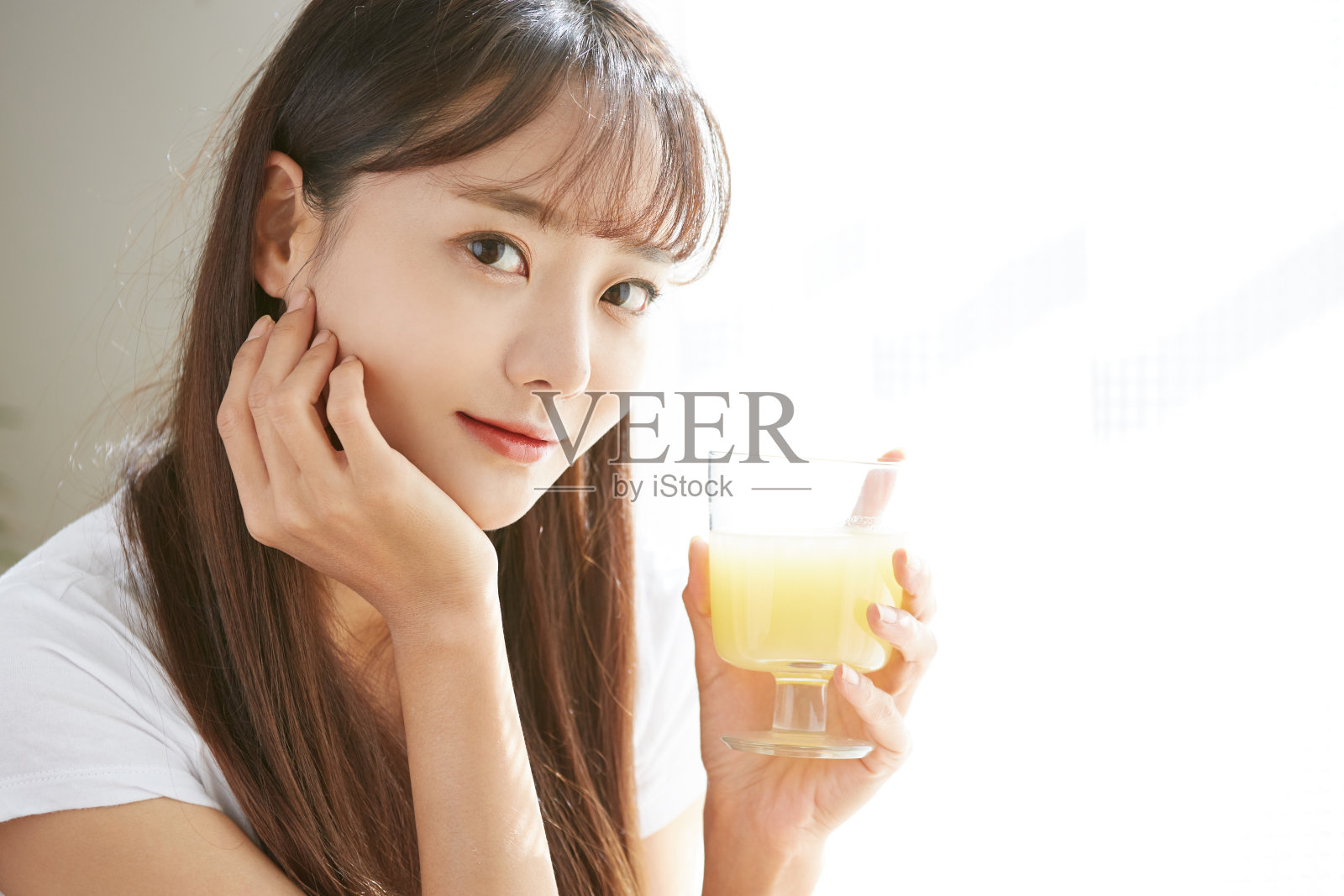 一个年轻的亚洲女人在喝果汁照片摄影图片