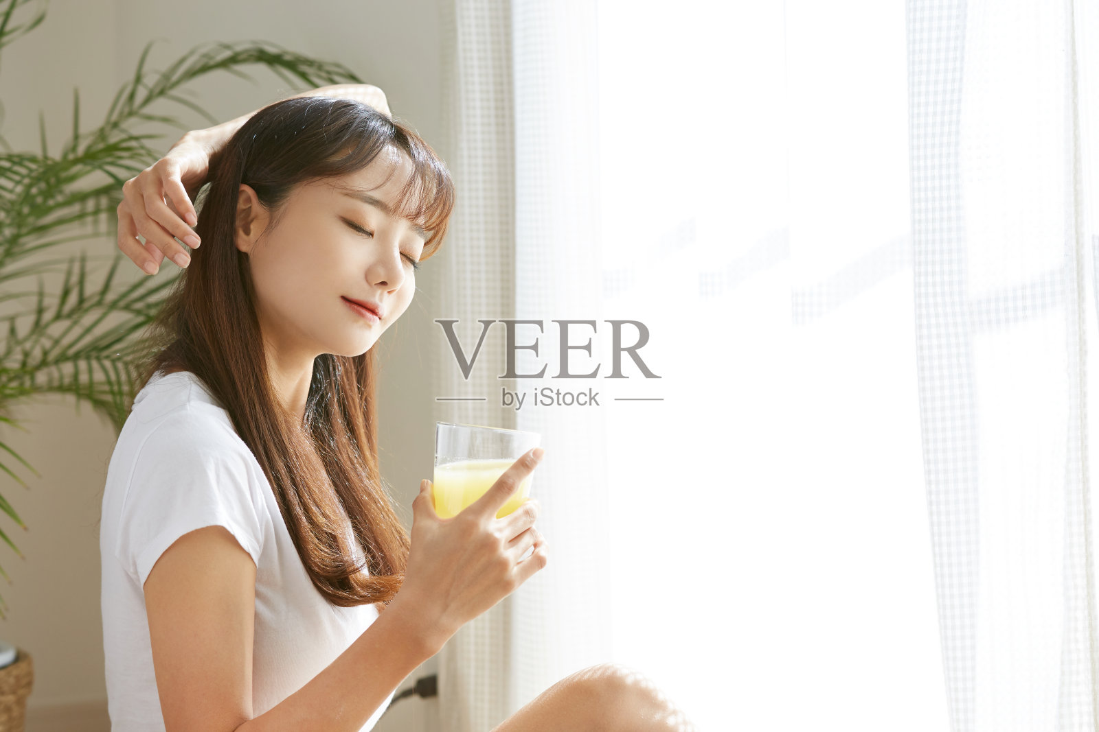 一个年轻的亚洲女人在喝果汁照片摄影图片