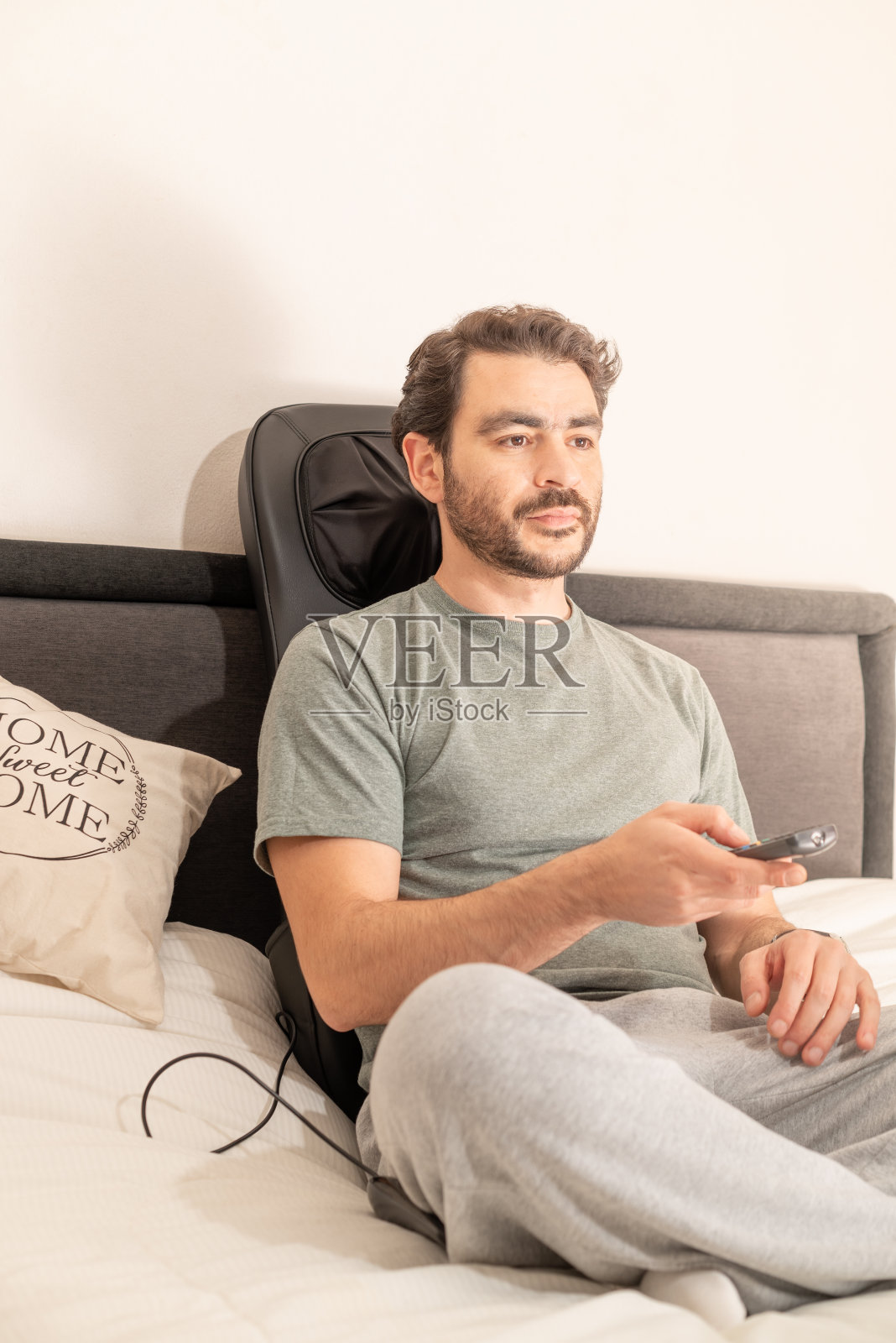 男人在家工作，床上放着笔记本电脑和智能手机照片摄影图片