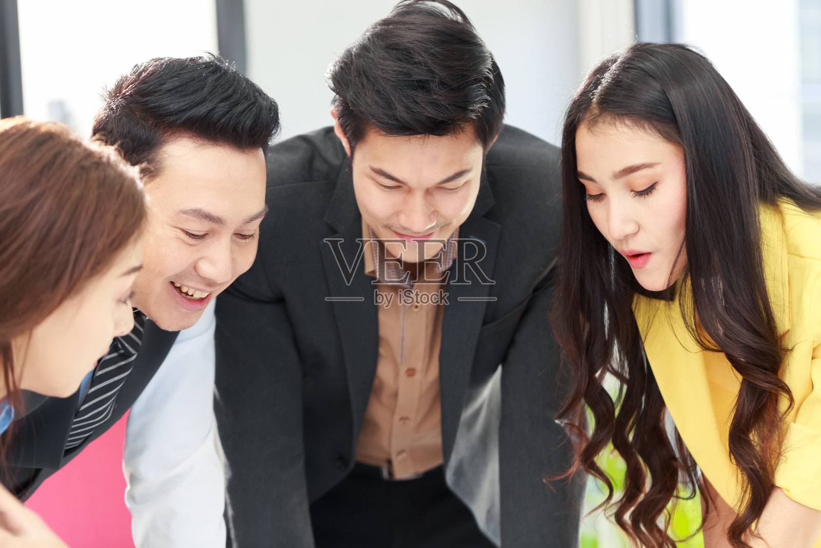 一群年轻的亚洲业务团队在办公室一起工作。办公室商务人员在会议上进行头脑风暴。启动业务团队，讨论新项目。照片摄影图片