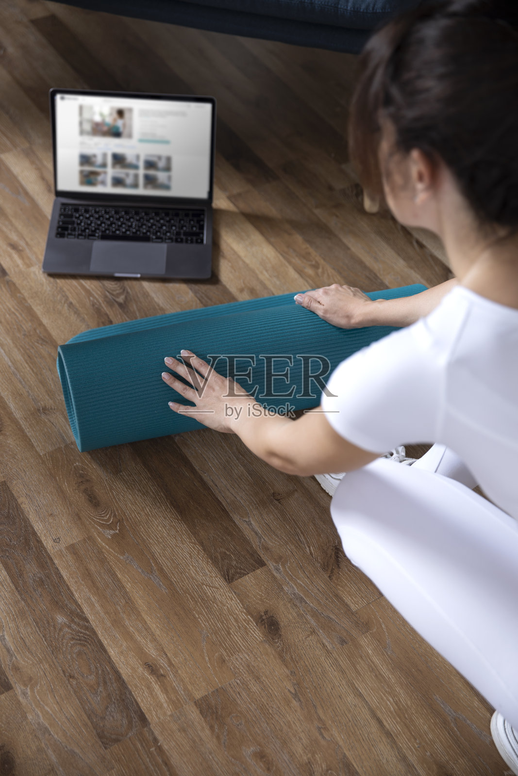 年轻的运动女孩准备在家里在线锻炼。在家做普拉提和瑜伽。照片摄影图片