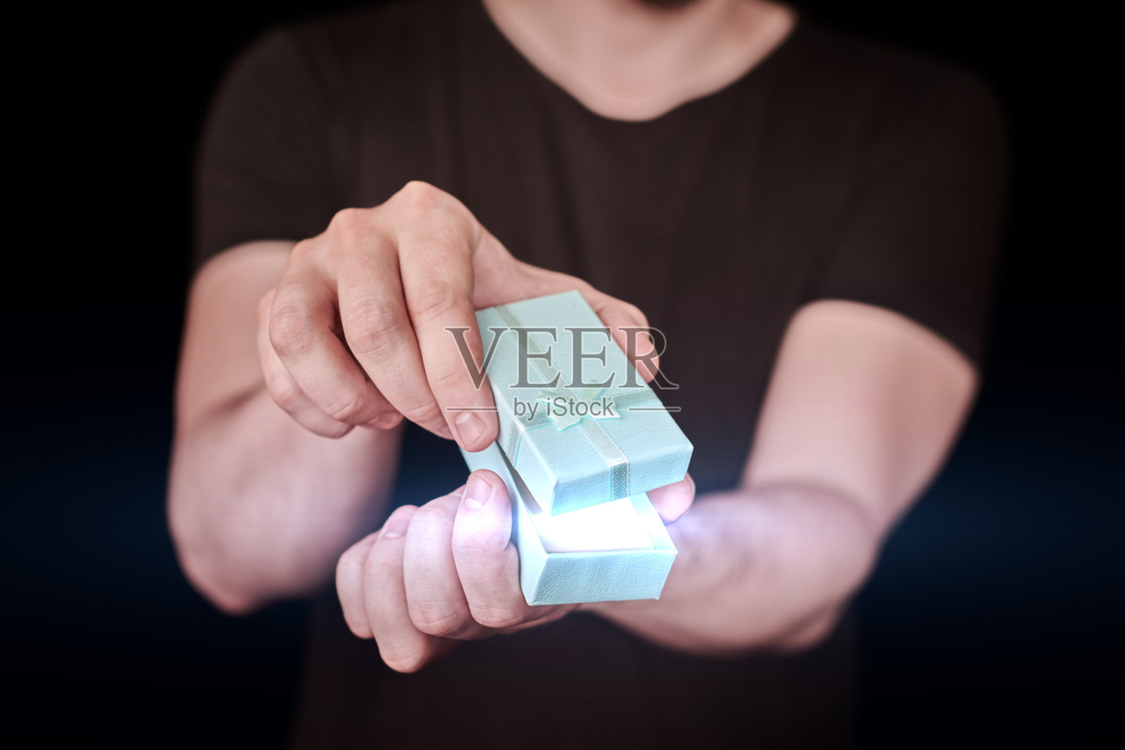 情人节，男人送了一个装在红色礼盒里的礼物照片摄影图片