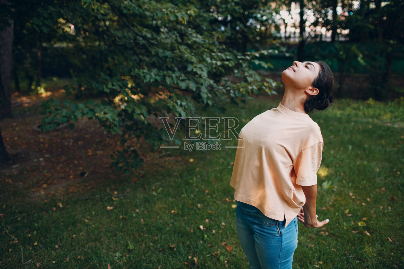 运动的千禧印度妇女穿着休闲装在公园训练前伸展，做热身运动照片摄影图片