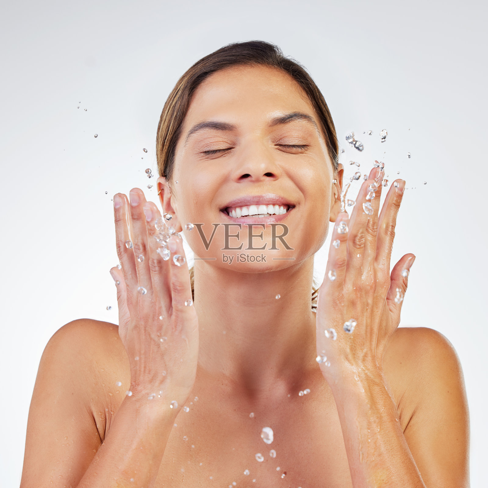 一个年轻的女人在工作室的背景下清洁她的皮肤照片摄影图片