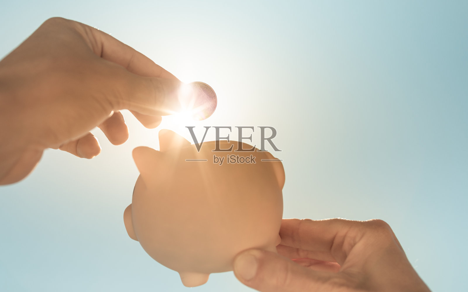 手把硬币放进存钱罐。为未来储蓄。照片摄影图片