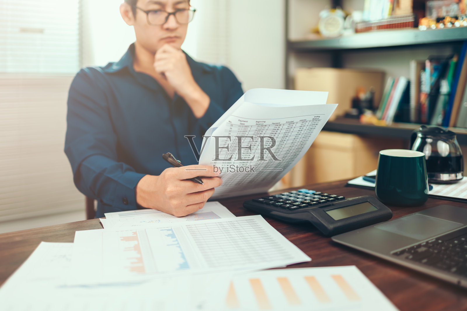 会计工作与数据表在办公室桌上。计算机与会计报告和财务报表在桌上。照片摄影图片