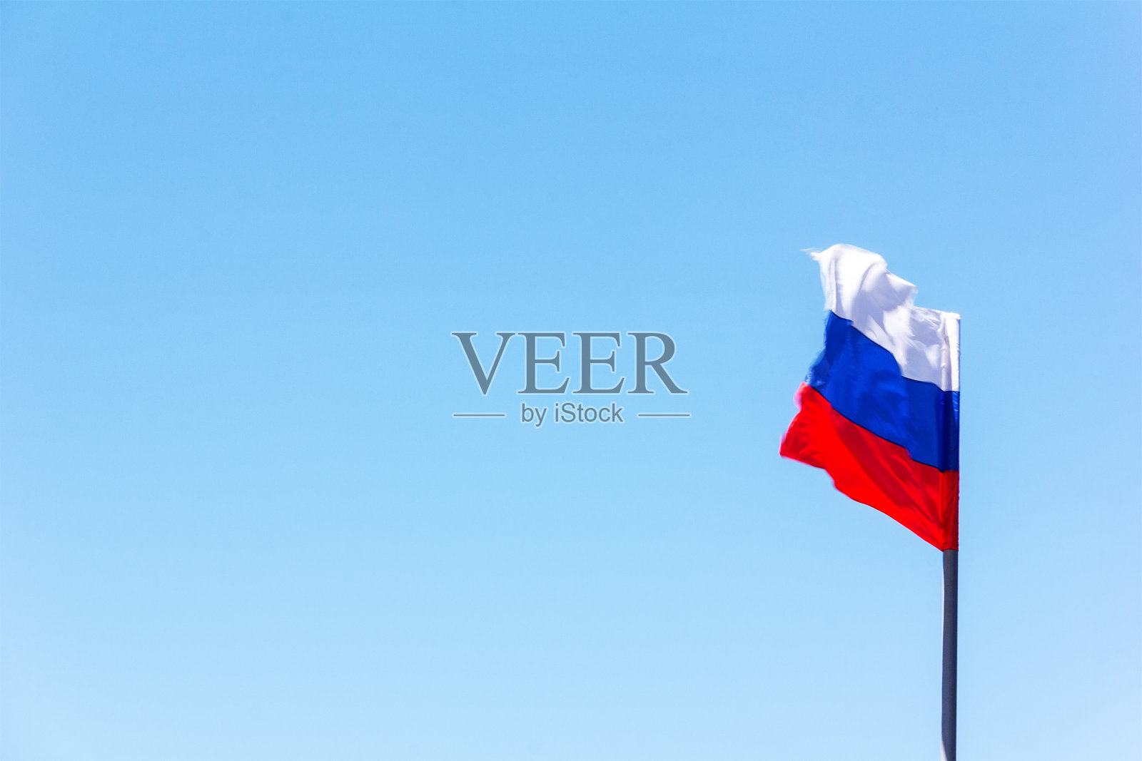 俄罗斯国旗迎风飘扬在蓝天上照片摄影图片