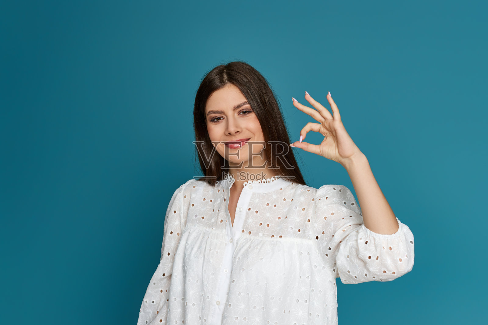 年轻女子穿着白色的衣服，举止得体照片摄影图片