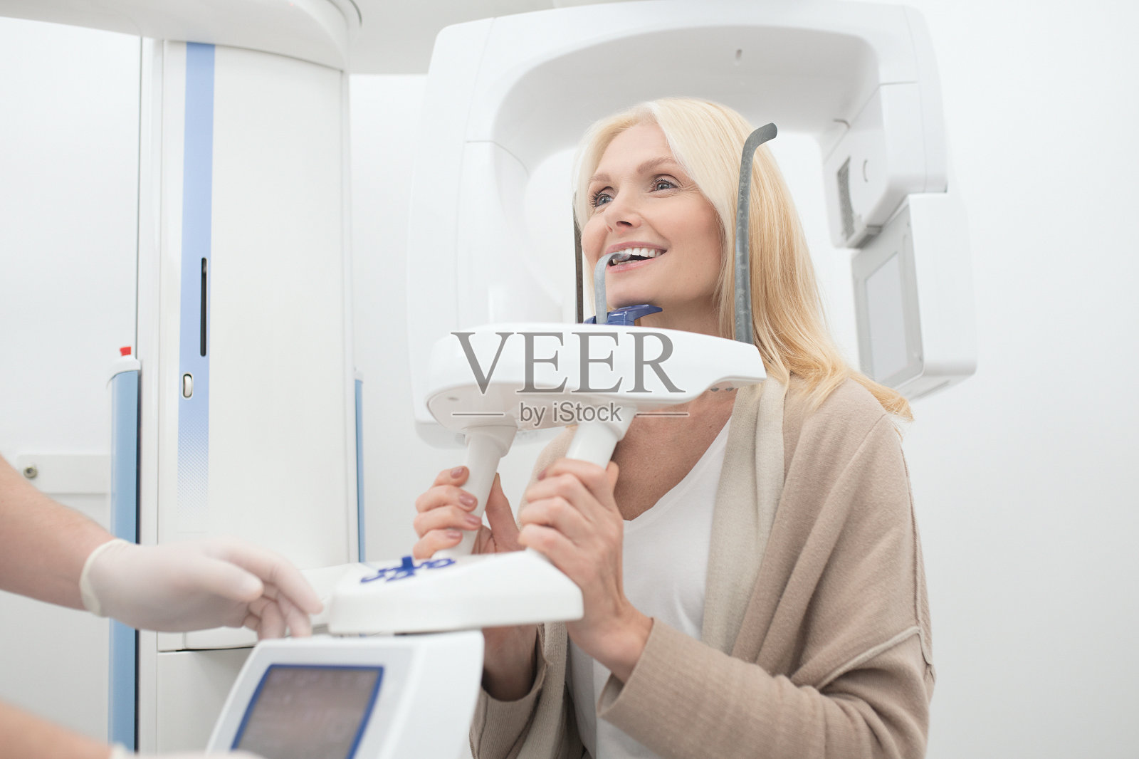 一个金发女人正在接受牙科治疗，感觉很好照片摄影图片