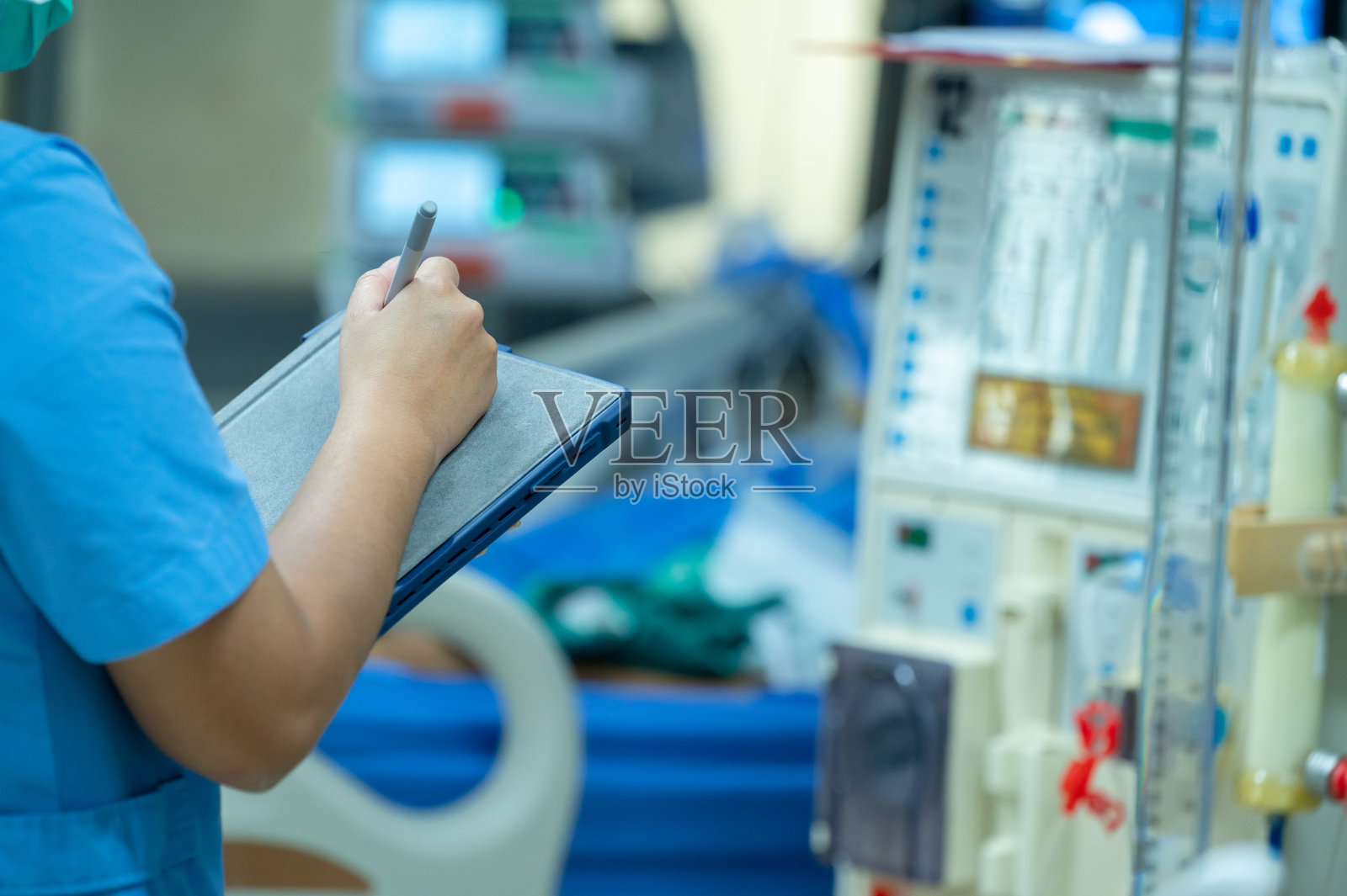 护理人员在慢性肾衰竭患者使用前检查血液透析机的功能。照片摄影图片