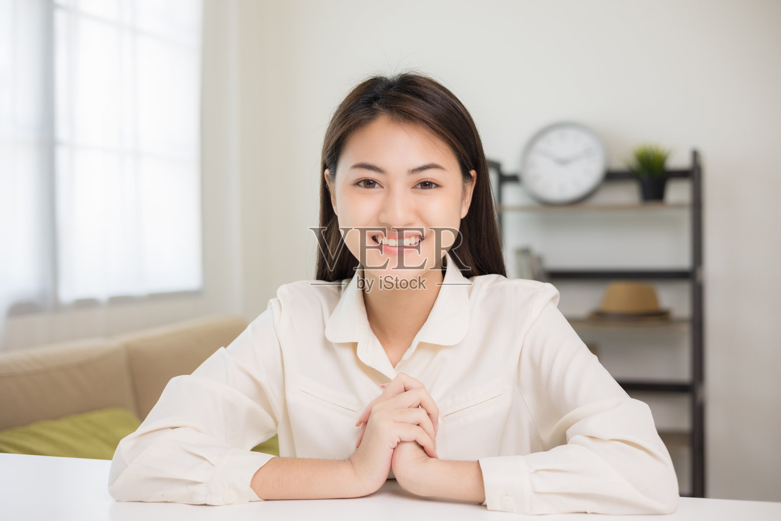 年轻的亚洲妇女看着摄像机视频会议在线坐在客厅在家里。商务女性看着屏幕在社交媒体直播蒸汽会议。工作，在家学习。照片摄影图片