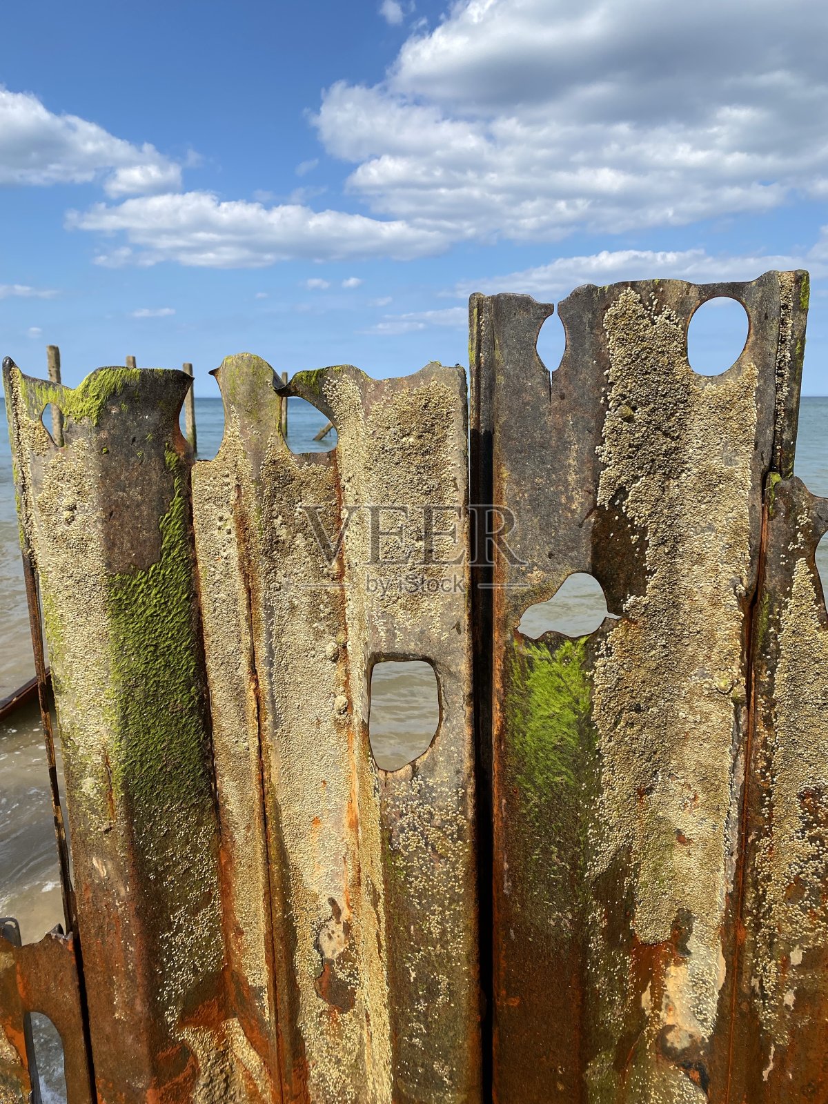 海边的一个生锈的旧金属栅栏。照片摄影图片