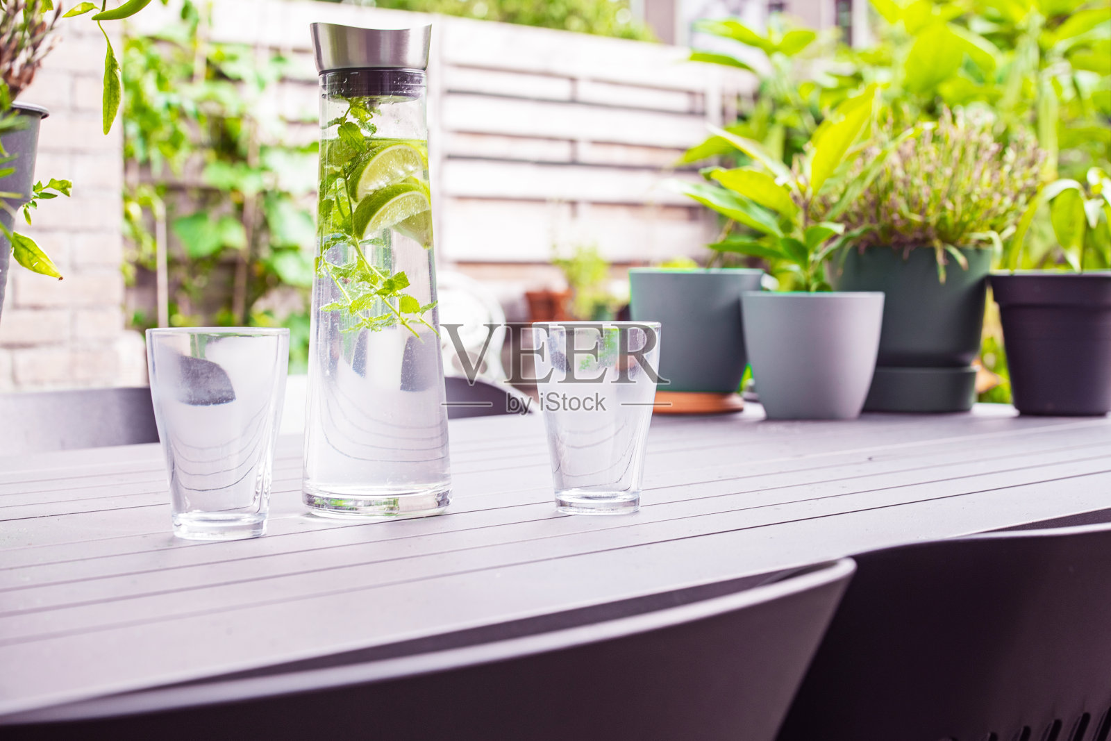 在花园里喝一杯加柠檬和薄荷的健康饮料。照片摄影图片