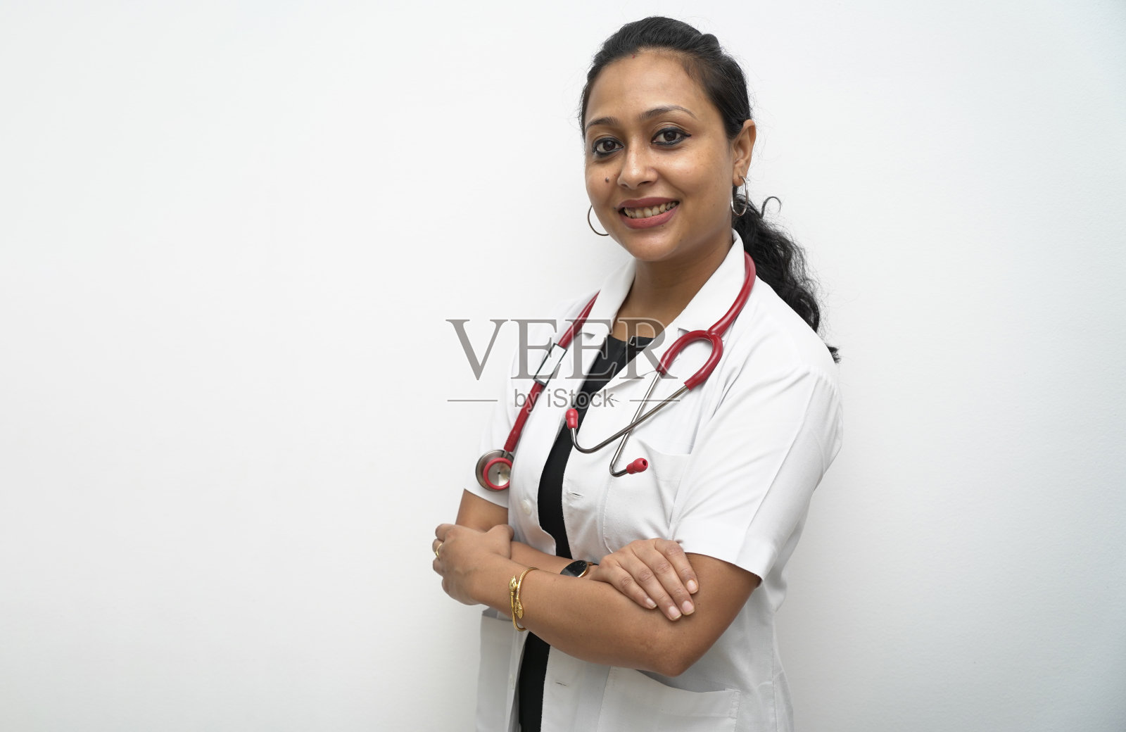 南印度女医生，30多岁，白大褂，白色背景红色听诊器。照片摄影图片