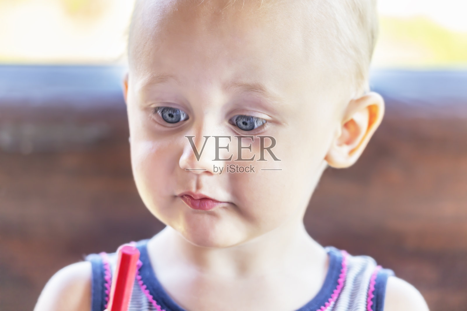 一个有趣的婴儿看着蜡笔的肖像照片摄影图片