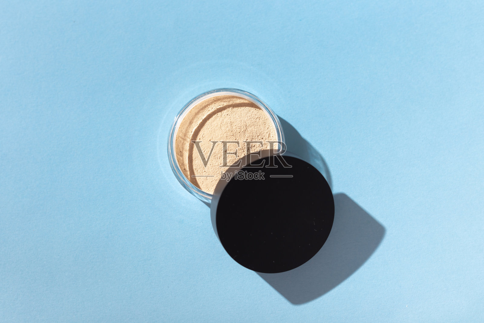 矿物粉底分离在蓝色背景。环保有机美容产品照片摄影图片