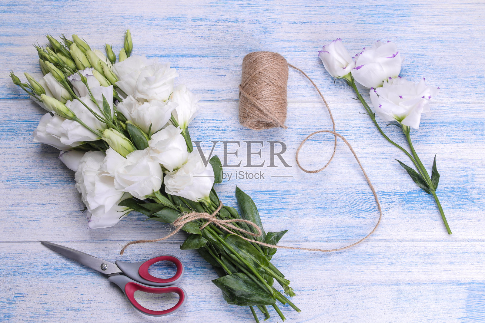 美丽的白色花束，有剪子和丝带，蓝色木制背景照片摄影图片