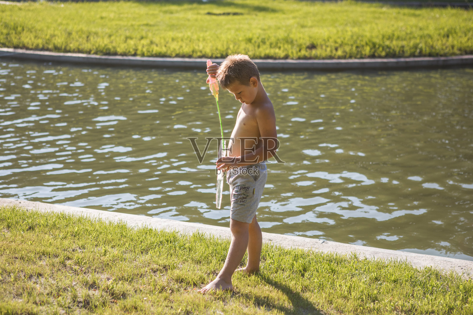 快乐的孩子在花园里追逐和玩肥皂泡，滑稽的孩子在夏天捕捉和破裂泡沫。小男孩在周末有乐趣，户外活动的儿童概念照片摄影图片