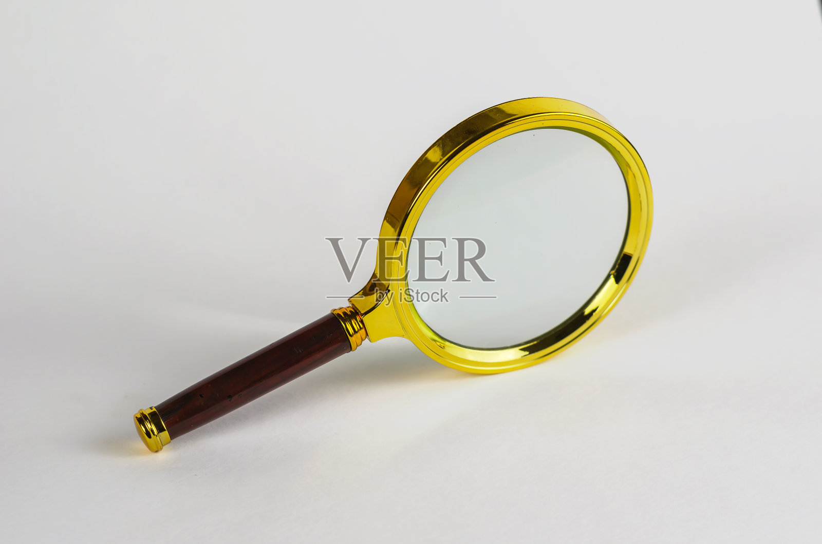 镀金镜框上有棕色把手的放大镜照片摄影图片