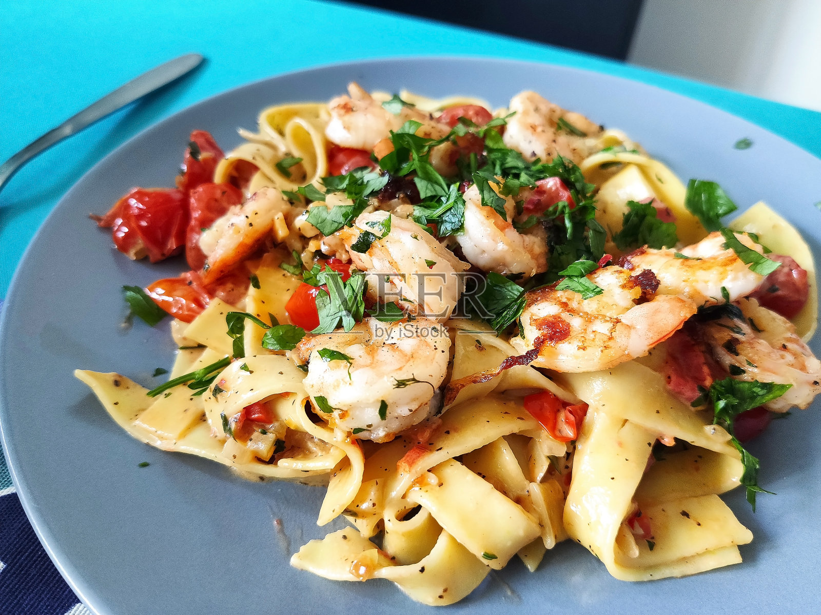 奶油意大利面，虾，西红柿和欧芹照片摄影图片