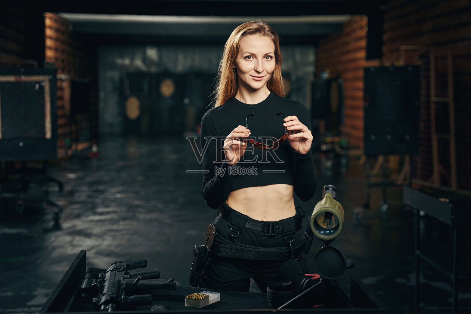 一名微笑的女性在射击场对着镜头摆姿势照片摄影图片