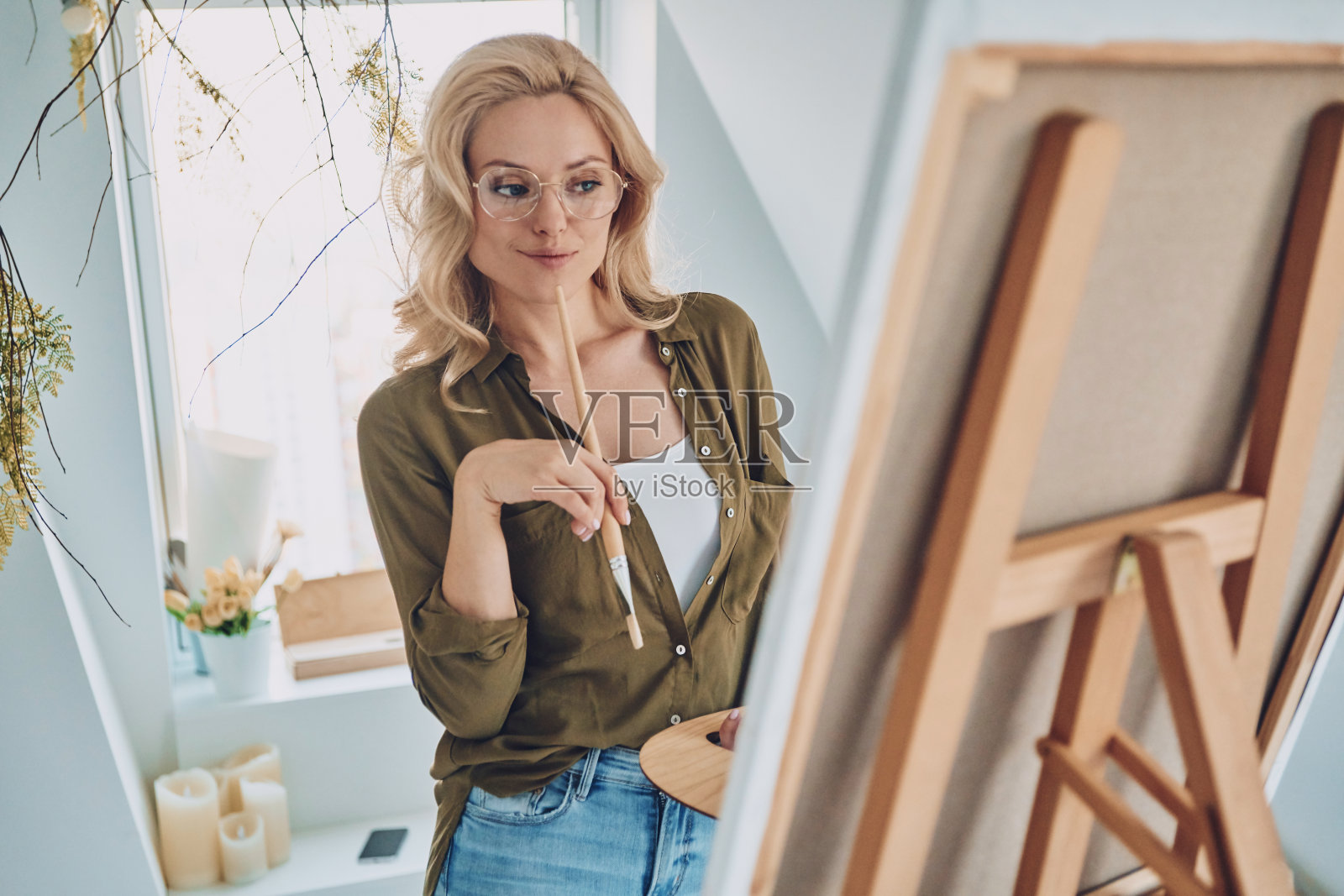 迷人的年轻金发女子在画室绘画照片摄影图片