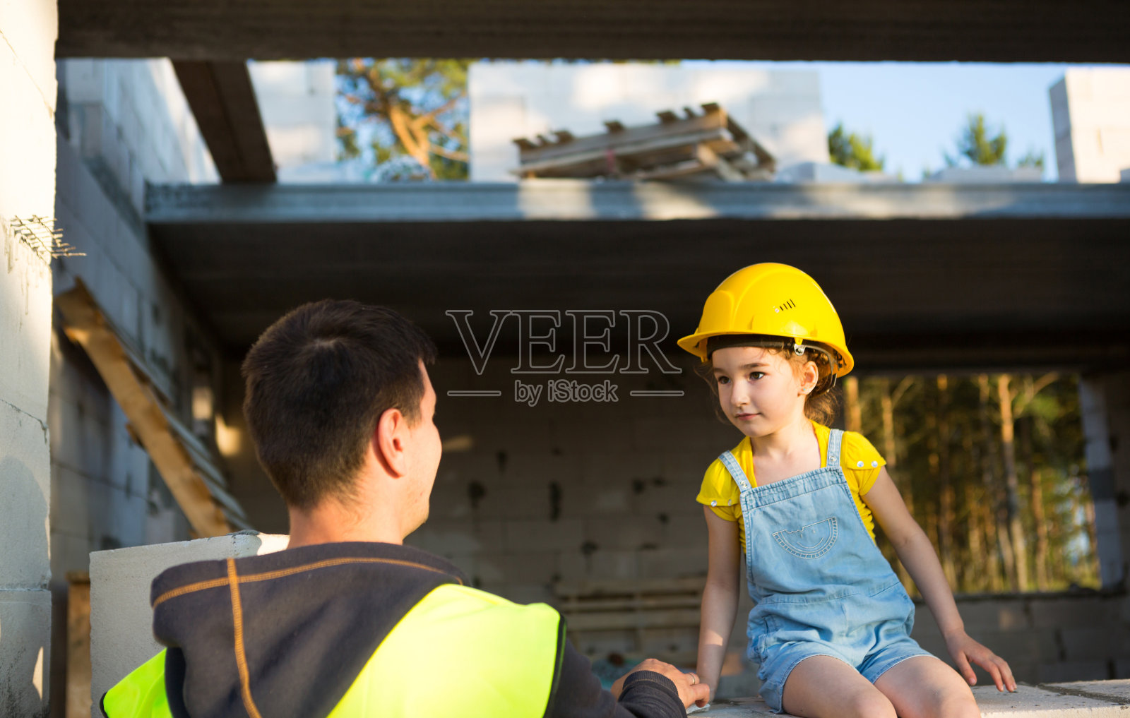 爸爸和女儿在他们未来的家的建筑工地。建筑师未来职业的选择是由孩子继承的。搬家的期望，有房子的梦想。抵押贷款,贷款照片摄影图片