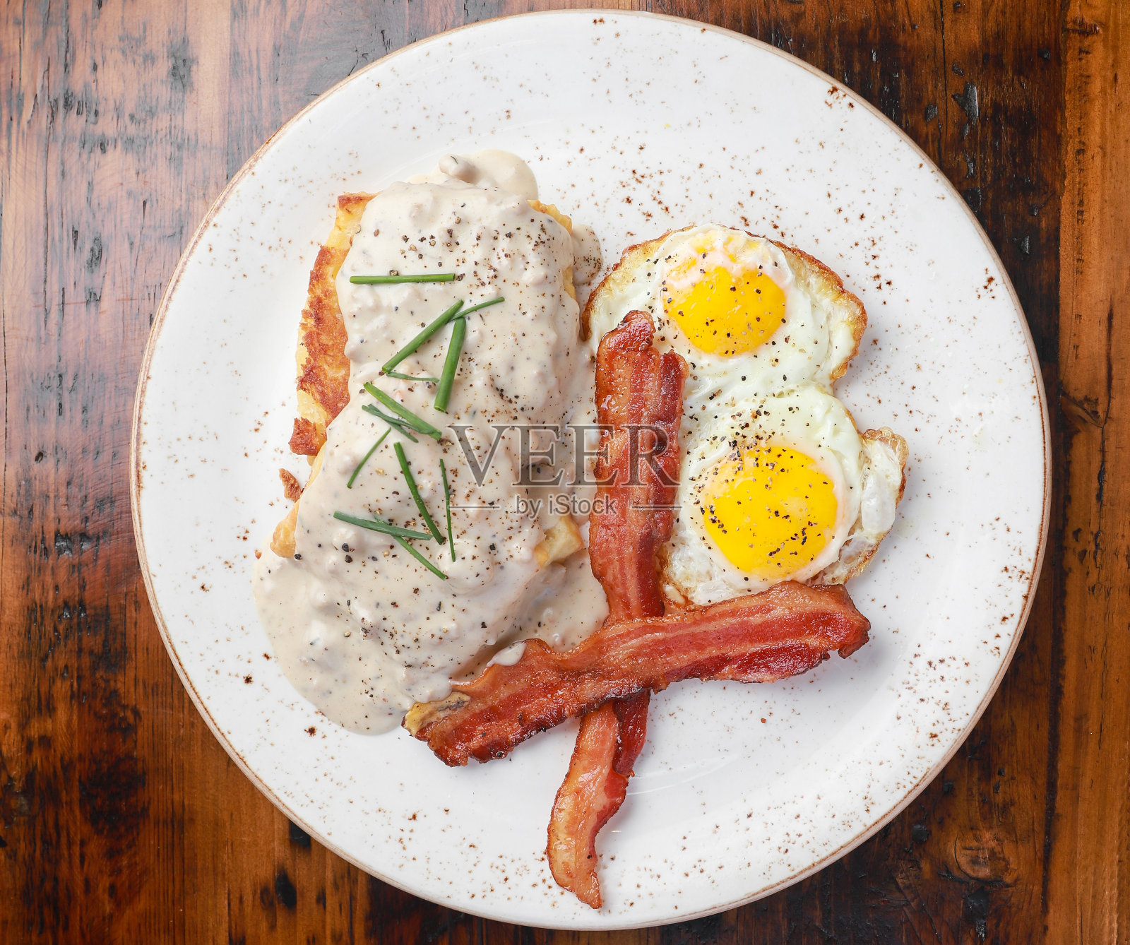 早餐有培根，鸡蛋，饼干和肉汁照片摄影图片
