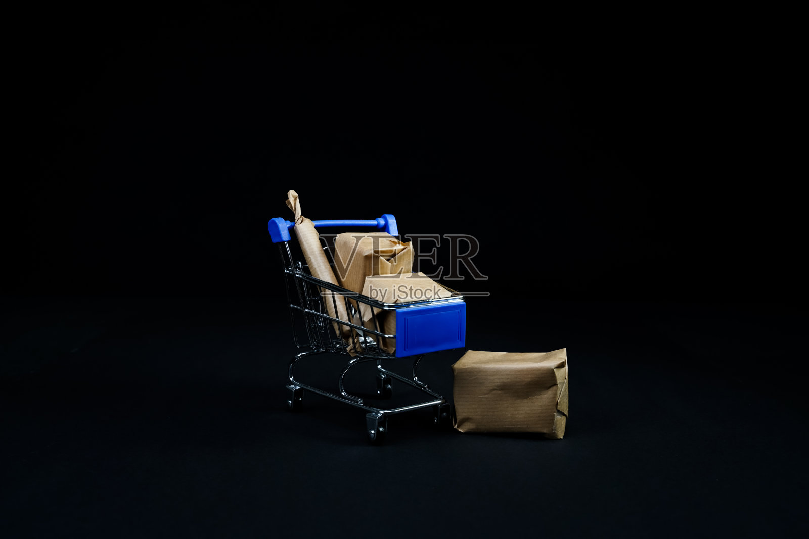网上购物后的小购物车和运输箱。孤立在黑色背景上。照片摄影图片