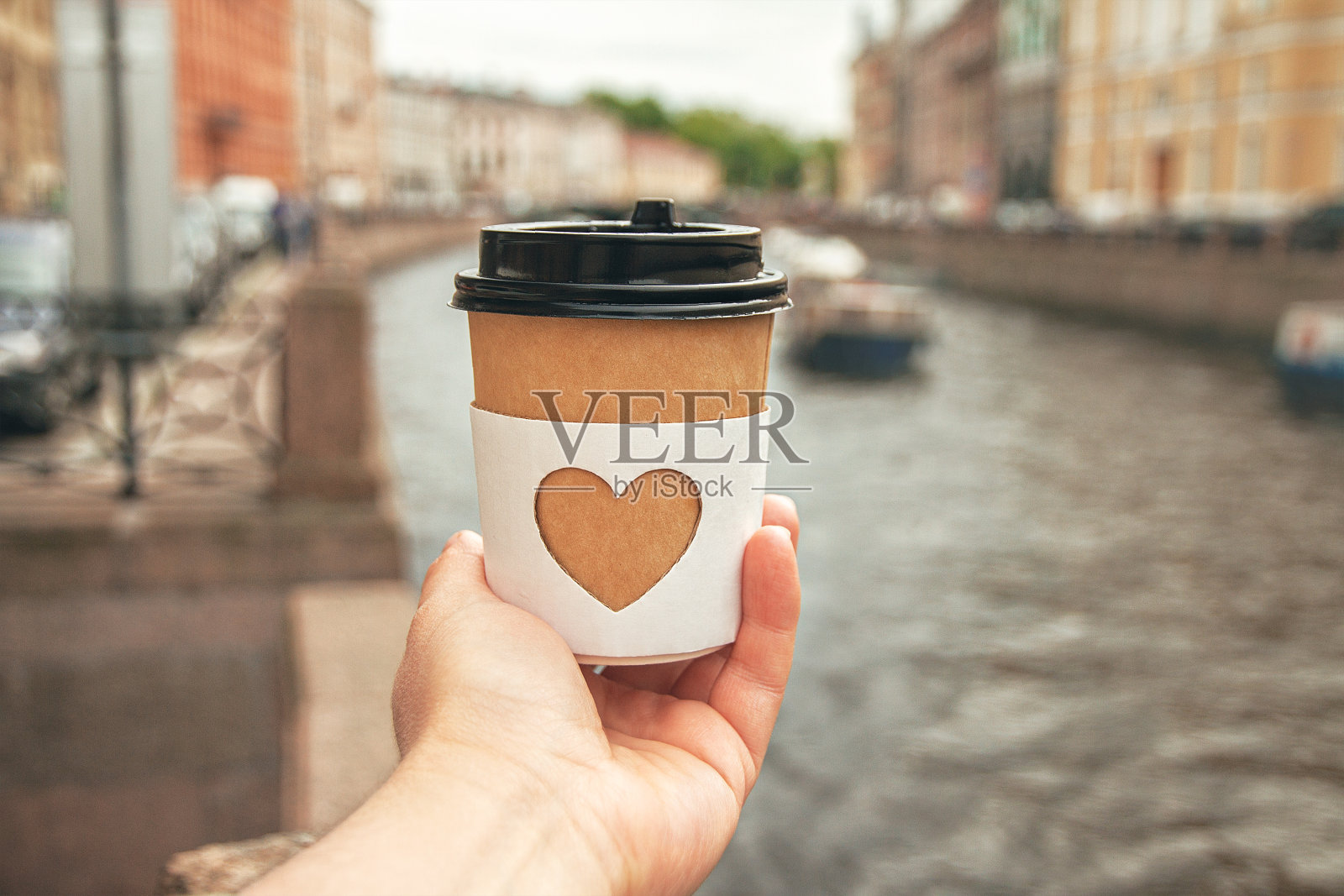 在圣彼得堡河的背景上，女人的手掌上的一杯天然咖啡照片摄影图片