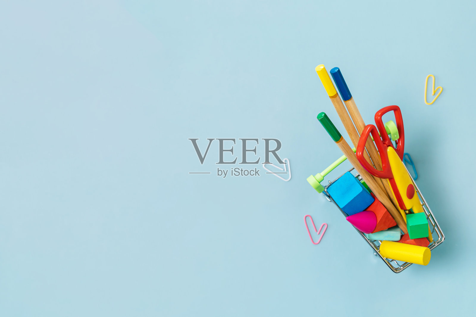 蓝色背景上的学习用品和回形针。回到学校的概念。COVID-19预防措施。俯视图平面背景。副本的空间。照片摄影图片