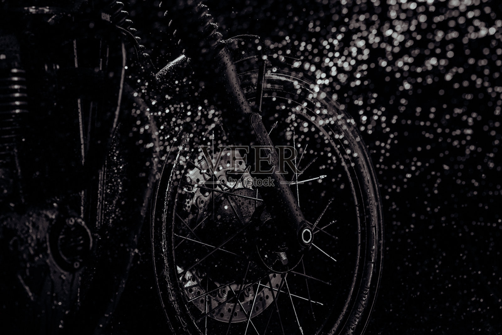 摩托车在洗后越野驾驶。用水清洗前轮，用盘式制动器。经典的黑色摩托车。Caferacers风格。汽车保养照片摄影图片