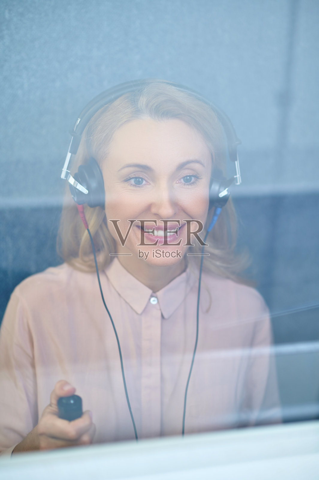 听诊室里戴着耳机微笑的金发女士照片摄影图片