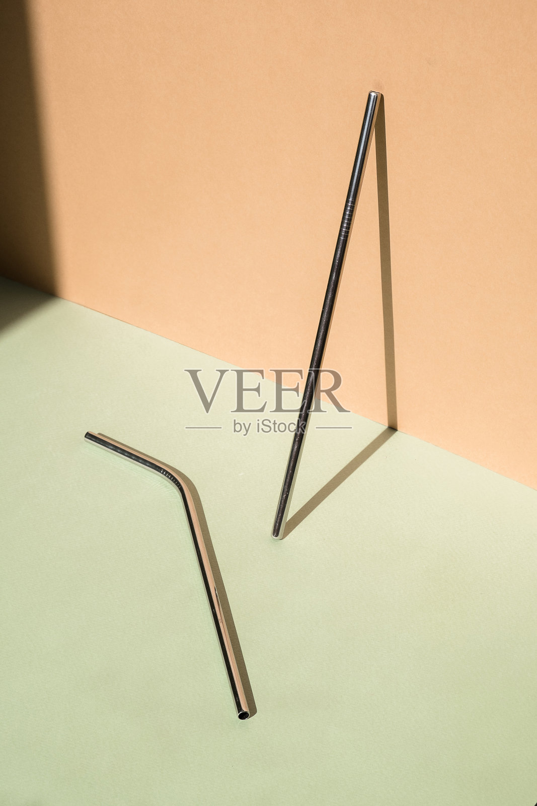 一套可重复使用的钢饮水吸管金属颜色的绿色和米色背景。可持续生活方式的概念。零浪费，不含塑料。停止塑料照片摄影图片