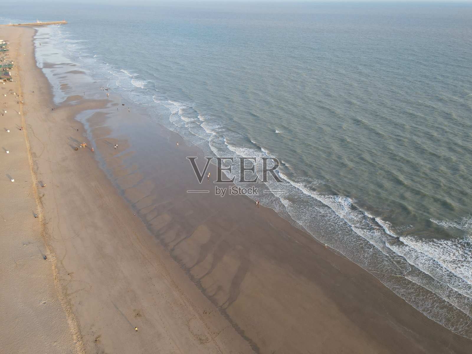 海滩无人机视野的印度海滩，白色的海滩与海浪，一对夫妇躺在海滩上的男人和女人照片摄影图片