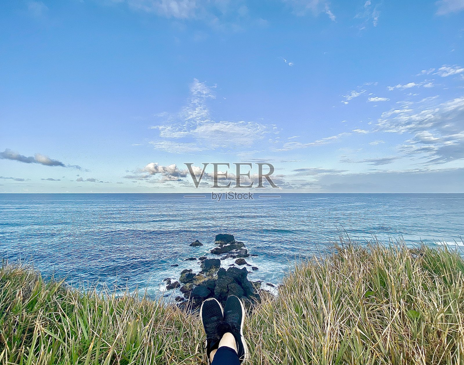 躺在海岬草地上眺望海景照片摄影图片