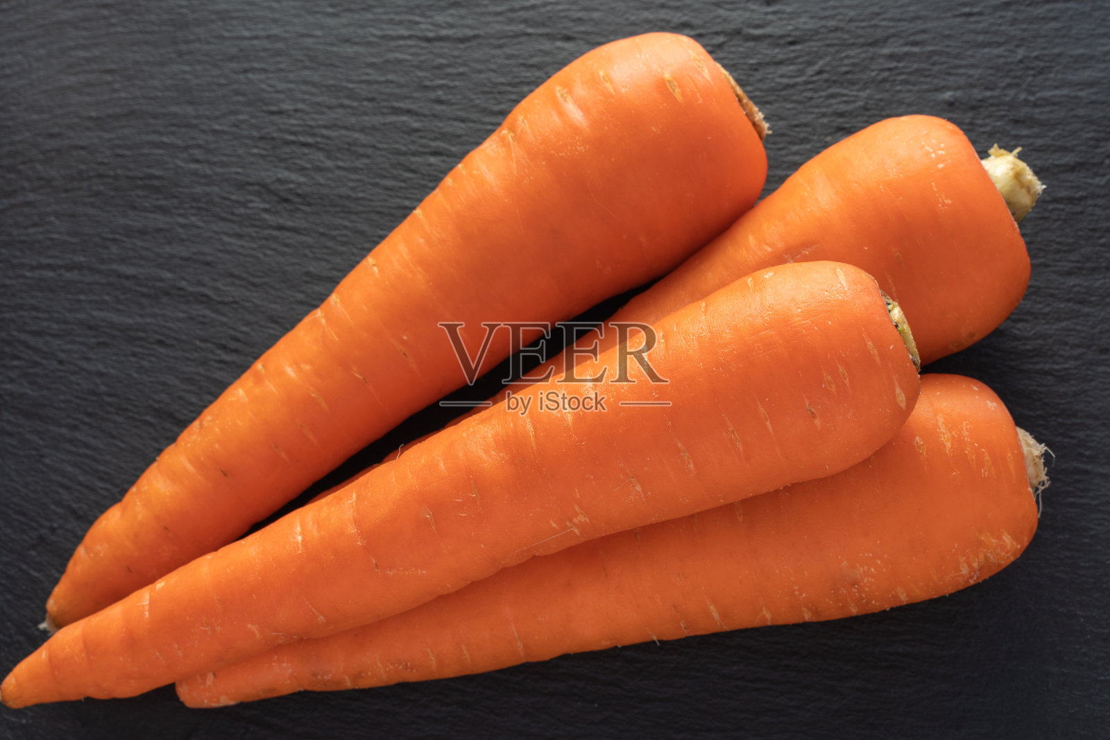 4片橙色胡萝卜，一种日本蔬菜(黑色背景)照片摄影图片