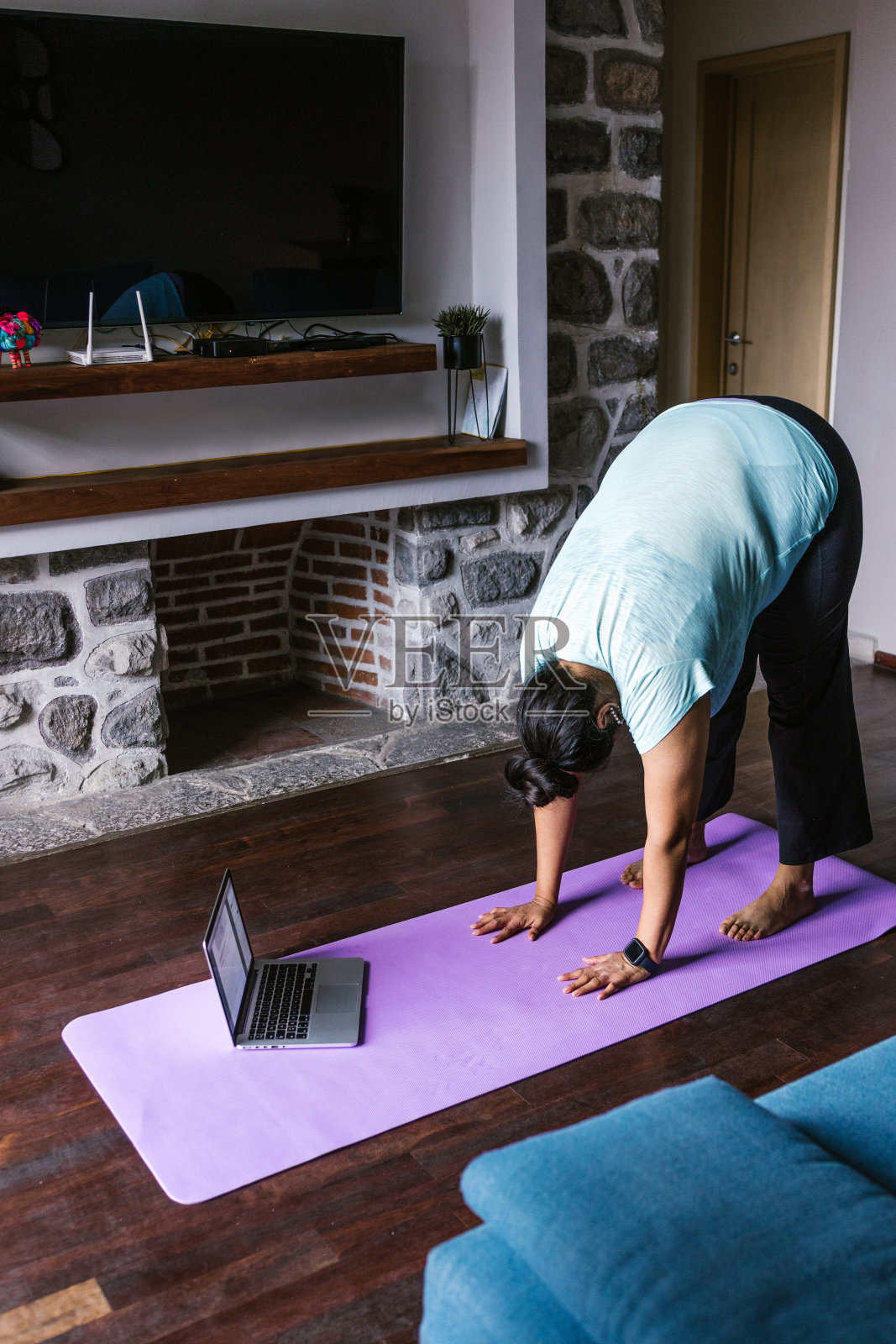 在墨西哥，年轻的超重西班牙妇女在家里用电脑锻炼，大码女性照片摄影图片