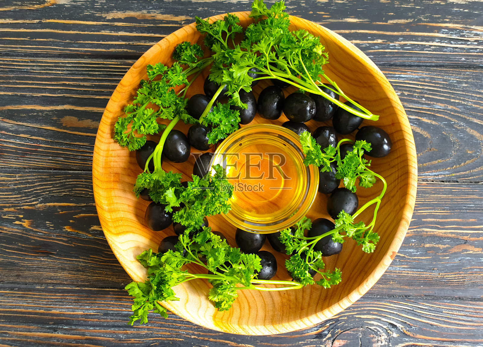 黑橄榄，木质背景上的油照片摄影图片