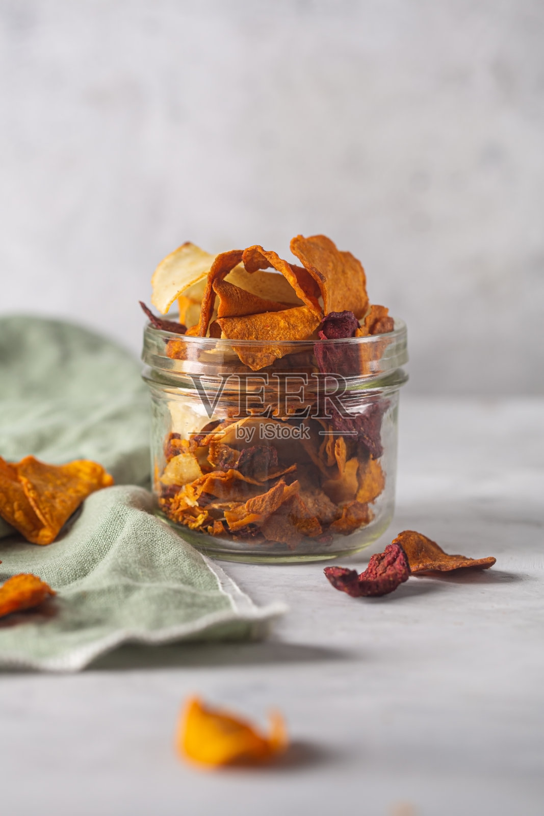 蔬菜片装在一个罐子里，用餐巾放在混凝土背景上照片摄影图片