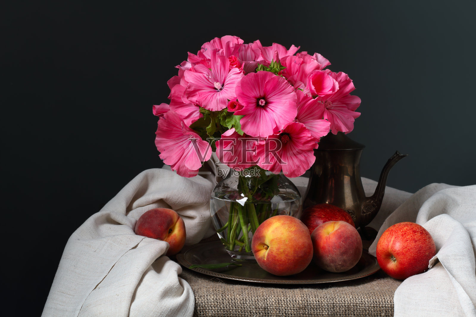 深灰色背景上的静物画，夏天的花朵和水果照片摄影图片