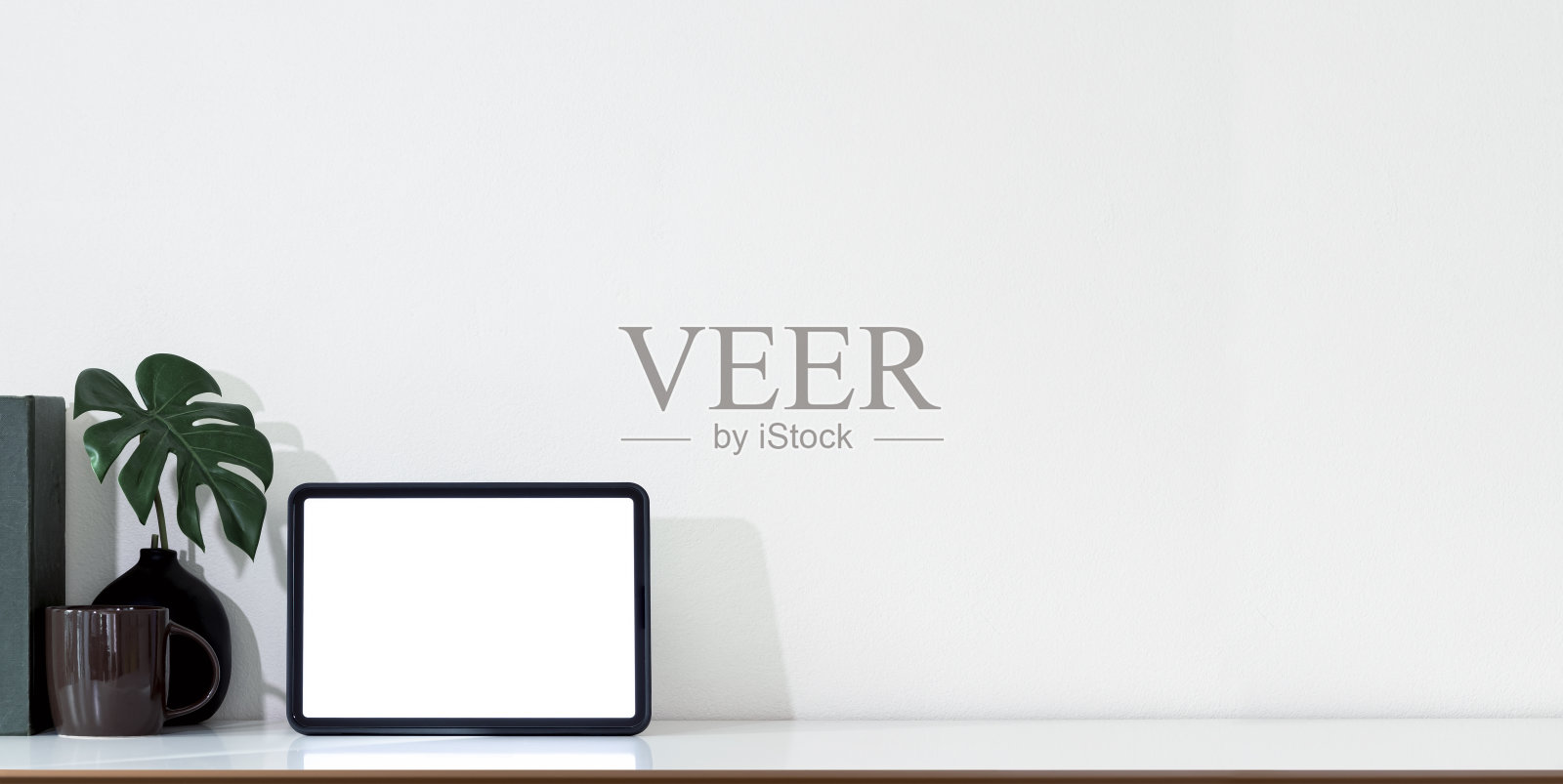 空白屏幕平板和带有复制空间的白色桌子上装饰对象的全景图。照片摄影图片