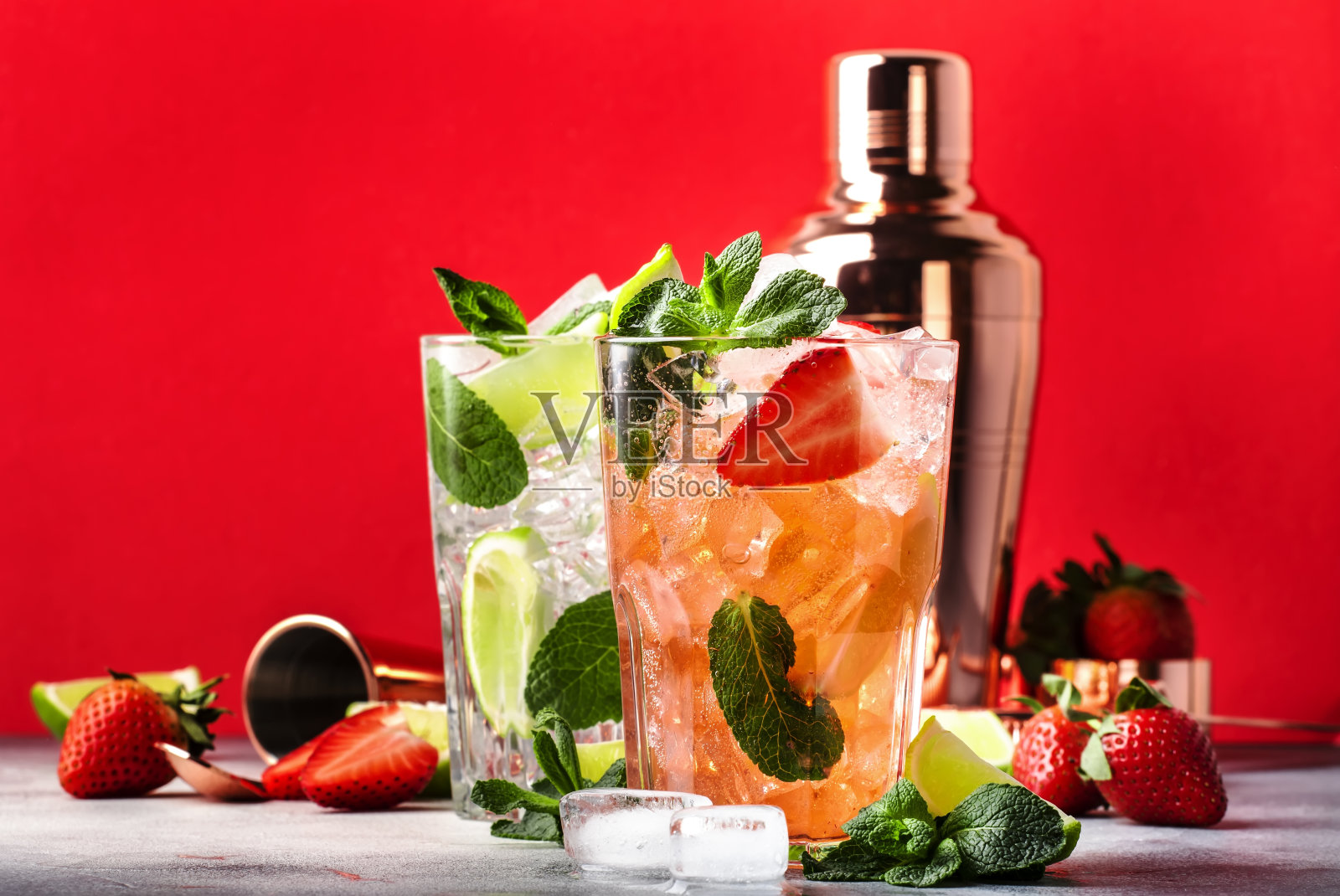 一杯莫吉托鸡尾酒或无尾鸡尾酒，在红色背景下加入酸橙、朗姆酒、薄荷、草莓和冰块照片摄影图片