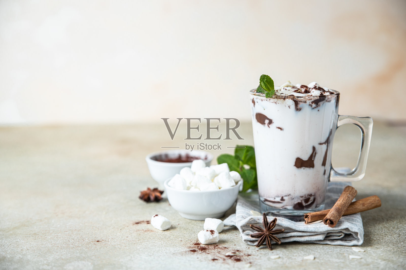 热巧克力或可可杯与棉花糖，肉桂和薄荷，浅色混凝土背景。照片摄影图片